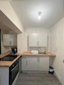 a kitchen with white cabinets and a sink at Flat 71 in Bristol