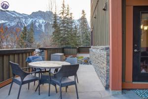 a patio with a table and chairs on a balcony at Chinook Manor in Canmore