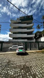 a white car parked in front of a building at Apt. em Praia do Sul de Ilhéus in Ilhéus