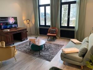 a living room with a couch and a tv at Royal South - Apartment Antwerp with Parkview in Antwerp
