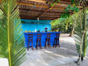 una barra azul con taburetes bajo una pared azul en Eco Hotel Las Palmeras, en Isla Grande