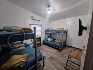 um quarto com três beliches e uma mesa em Hermosa Casa de Campo em Palomas