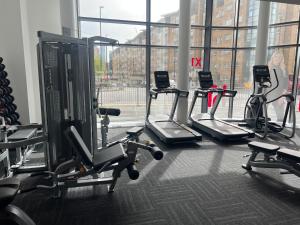 a gym with three tread machines and a large window at Salford Manchester in Manchester