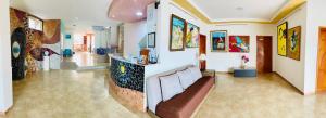 - un salon avec un canapé et des peintures murales dans l'établissement Eco Hotel Katarma, à Puerto Baquerizo Moreno
