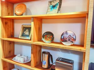 una estantería de madera con cuencos y una impresora. en The best warm home en Surrey