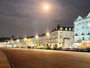 a large building with lights in front of it at night at Iris Hotel Llandudno in Llandudno