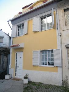 une maison jaune avec volets blancs dans l'établissement Sailor's House - Holiday's House, à Porto