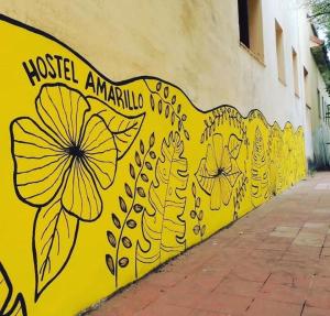a yellow wall with flowers painted on it at Hostel Amarillo in San Ignacio