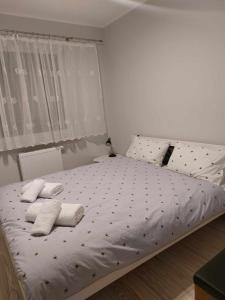 a bedroom with a bed with two towels on it at Bee Happy Apartament Wrzesnia ll in Września