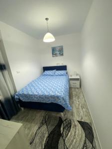 a bedroom with a bed with a blue comforter at Apartman Vasilije in Divčibare