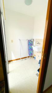 a room with a white tiled floor and a sink at Mimi’s Dream Luján 2 in Luján