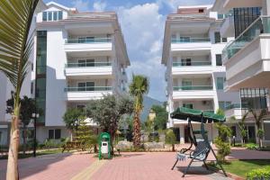 un edificio con una palmera delante de él en River Suite, en Alanya