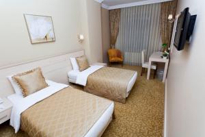 um quarto de hotel com duas camas e um sofá em Classes Hotel em Istambul