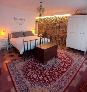 una camera con un letto e un tappeto con un tavolo di Casa Longhi a Orta San Giulio