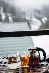 a table with two glasses of tea and a coffee pot at Nikol Guest House in Bukovel