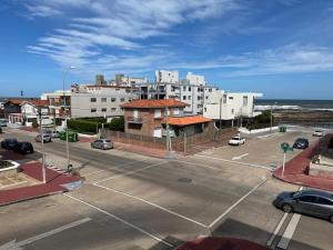 un parking vide avec des bâtiments et l'océan dans l'établissement Club del Mar, à Punta del Este