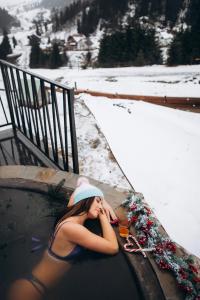 a woman laying in a swimming pool in the snow at Nikol Guest House in Bukovel
