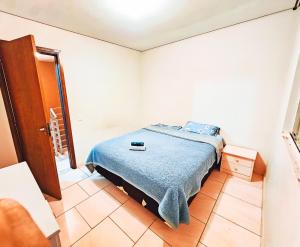 ein Schlafzimmer mit einem Bett mit einer blauen Decke in der Unterkunft Casa para Hospedar in Fazenda Rio Grande