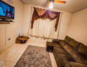 ein Wohnzimmer mit einem Sofa und einem Flachbild-TV in der Unterkunft Casa para Hospedar in Fazenda Rio Grande