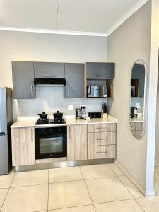 una cocina con electrodomésticos de acero inoxidable y armarios de madera en Apartment in Midrand, en Midrand