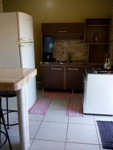 uma cozinha com um frigorífico branco e uma mesa em AP praia Itaguaçu São Chico em São Francisco do Sul
