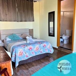 a bedroom with two beds and a bathroom with a toilet at Pousada Penha II Beto Carrero in Penha