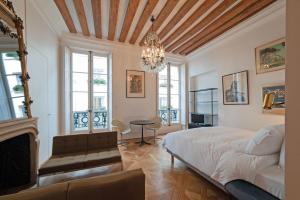 a bedroom with a bed and a chandelier at Pavillon Marais in Paris