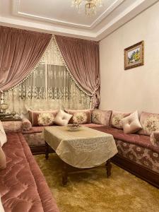een woonkamer met een bank en een tafel bij Luxurious Family Holiday Home in Temara
