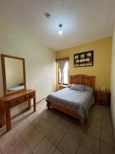 Un dormitorio con una cama, una cómoda y un espejo. en Hotel La Capilla Bernal, en Bernal