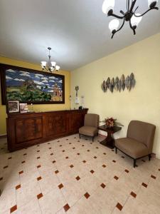 una sala de espera con 2 sillas y una pintura en la pared en Hotel La Capilla Bernal, en Bernal 8 fotos más