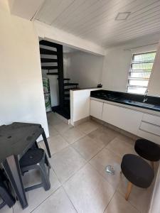 een keuken met een tafel en krukken in een kamer bij Pousada Ponta dos Corais in Guarujá