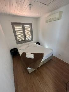 een slaapkamer met een groot wit bed en een raam bij Pousada Ponta dos Corais in Guarujá