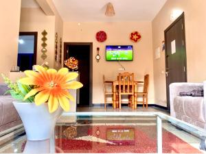 a living room with a vase with a yellow flower at la casa bella 5 minutes de la plage in Essaouira