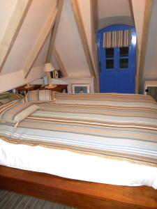 a bed in a room with a blue door at Ty Papy in Bénodet