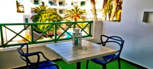 una mesa y sillas en un balcón con vistas en Cactus, Playa Y piscina, en Costa Teguise