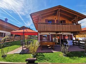 a log house with a deck and a table at Feriendorf Via Claudia Haus 82 Alpensee in Lechbruck