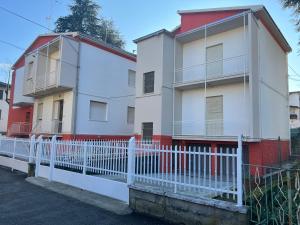 une clôture blanche devant un bâtiment dans l'établissement La casa sui colli bolognesi, à Savigno