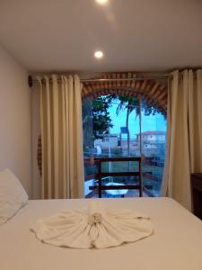 1 dormitorio con cama y ventana grande en Pousada Água de Fuego, en Maragogi