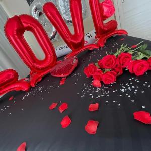 Um bolo dos namorados com rosas vermelhas e um sinal de amor em Atena B&B APARTMENTS Gold em San Silvestro