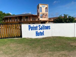 a sign on a fence in front of a house at Point Salines Hotel in Gwa Kay