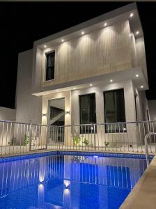 a swimming pool in front of a house at night at بببببب 