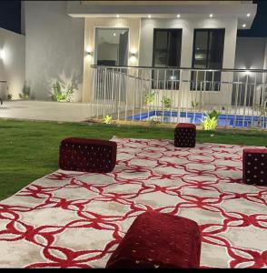 a patio with two chairs and a rug in front of a house at بببببب 