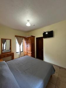 Un dormitorio con una cama y un televisor en la pared. en Hotel La Capilla Bernal, en Bernal