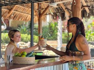 duas mulheres sentadas à mesa com uma bebida em Hotel Vista Bonita em Parrita