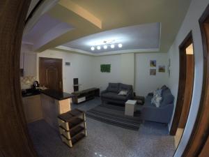 een woonkamer met 2 banken en een keuken bij Andalusia Resort - 2 Bedroom Apartment in Hurghada
