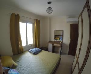 een slaapkamer met een groot bed en een raam bij Andalusia Resort - 2 Bedroom Apartment in Hurghada