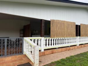 eine Veranda mit weißem Geländer an einem Haus in der Unterkunft Casa DeLyZy in Matoury