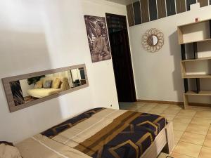 - une chambre avec un lit et un miroir mural dans l'établissement Casa DeLyZy, à Matoury