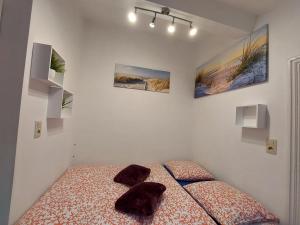 una camera con un letto con due cuscini sopra di Maison LYDIE - Meublé de vacances 3 étoiles a Charleroi
