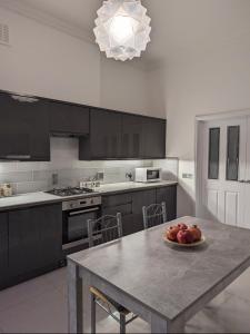 a kitchen with a table with a bowl of fruit on it at Victorian Apartment on the Famous Essex Rd in Islington in London